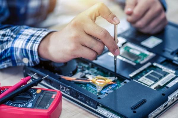 Stock photo showing someone with a screwdriver repairing a computer circuit board