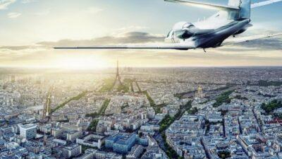 Picture of a small jet flying high above Paris, with Eiffel Tower in the far distance