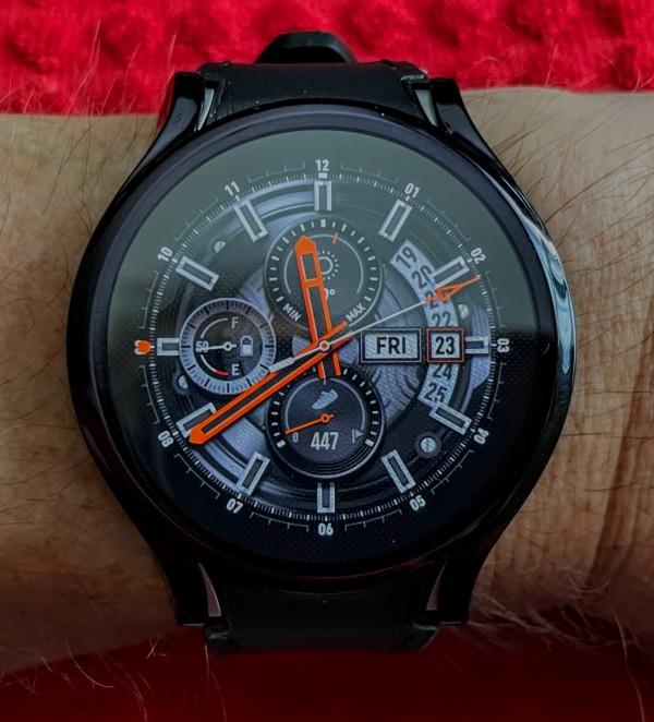 Samsung Galaxy Watch 5 with a  chronometer watch face with orange hands