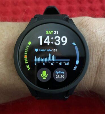 Photo of a Samsung Galaxy Watch 5 on a wrist, with the watch face showing digital time 14:39 and a graph with the heart rate during the day