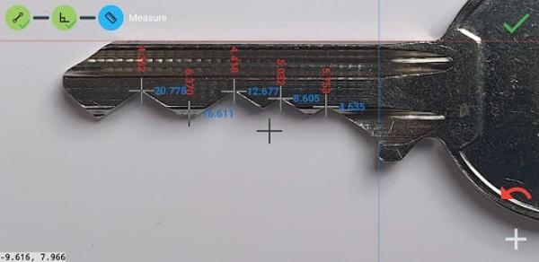Close view if a metal key, with measurements shown for dept and width of various teeth