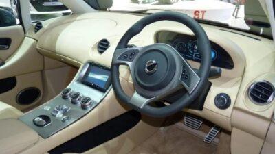 Interior view of a car showing steering wheel and tan coloured upholstery