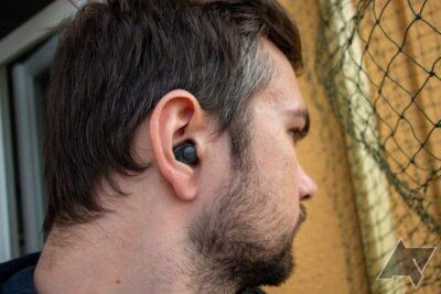 Side view of a man's head, wearing an earbud in his ear