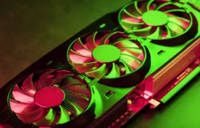 Close view of two cooling fans on a graphics card, bathed in red and green coloured lighting