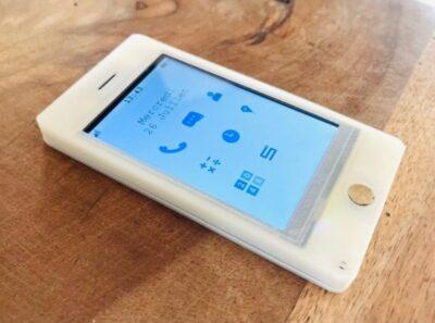 DIY cell phone made from white 3D printed material with a rectangular black&white touchscreen showing some icons