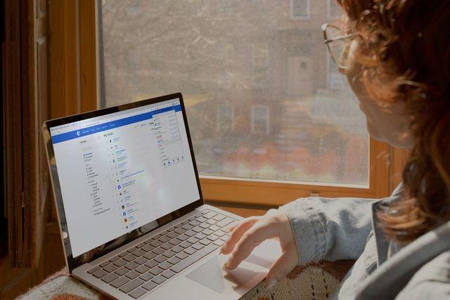 Woman typing on a silver colour laptop