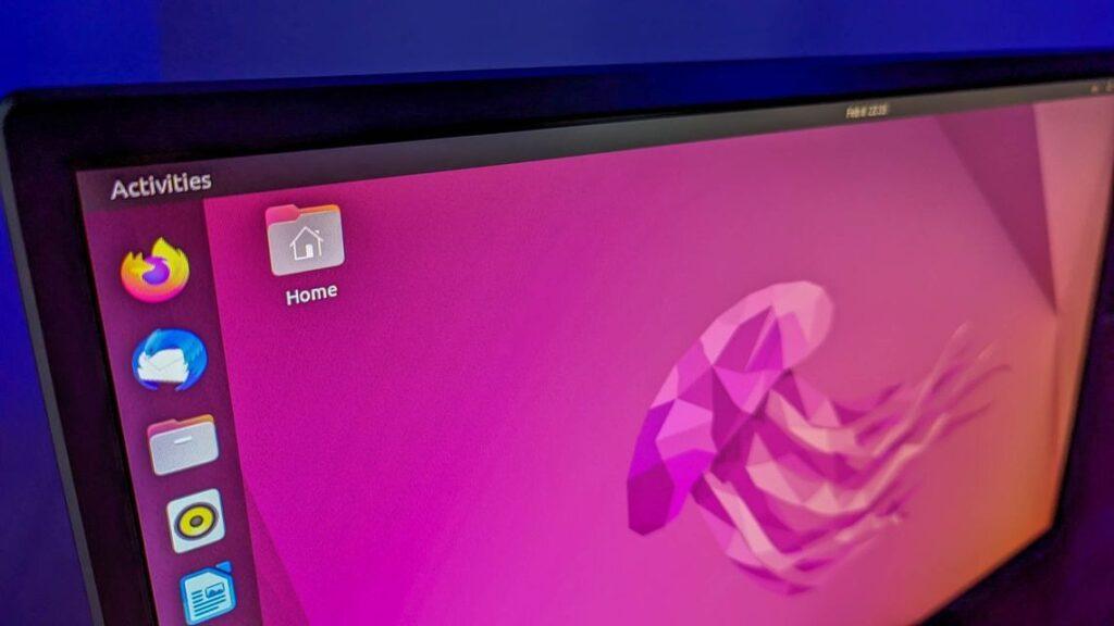 Pinkish coloured Linux desktop screen showing a home icon on the screen, and along the left side vertically are icons for Firefox browser, Thunderbird mail, etc.