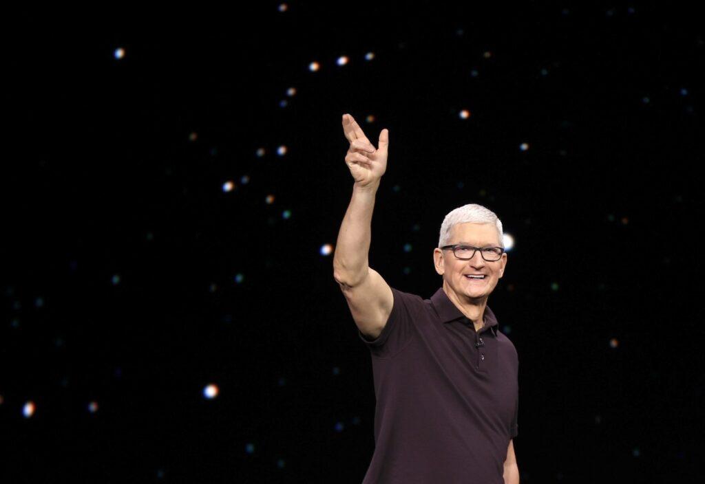 Tim Cook standing with one arm upraised