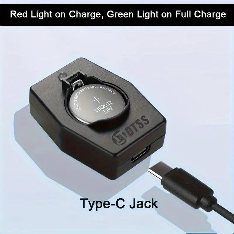 Small black plastic battery charger holding a coin cell size battery in it