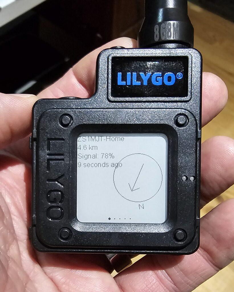 Palm-sized radio device with an e-ink screen showing a distance and direction to a connected node, the signal strength, and how long ago it connected.