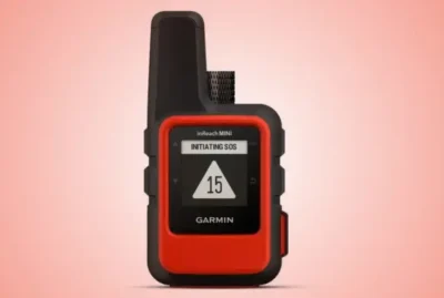 Garmin InReach staellite communicator - looks like a palm size red and black mobile phone. Display shows "Initiating SOS" with the number 15 shown.