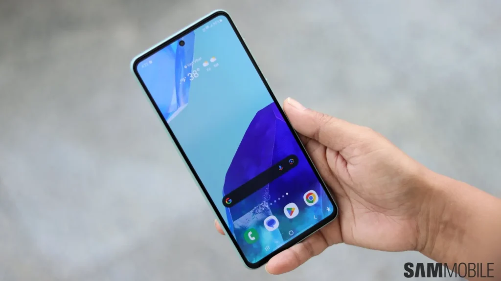 Samsung Galaxy phone held in a hand. The screen shows the standard blue/purple/turquoise screen background with a Google search bar near the bottom of the screen. At the bottom is a navigation bar with for icons on for phone, messages, play store, and Chrome browser.