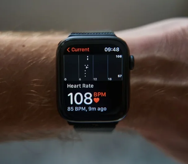 An Apple Watch showing the heart rate of 108 BPM and 85 BPM 9m agao. It also shows a scatter graph with a few dots in a colum.