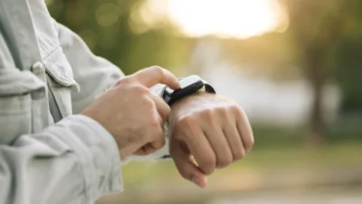 A wrist with an Apple Watch on it. Other hand has the index finger touching the screen.