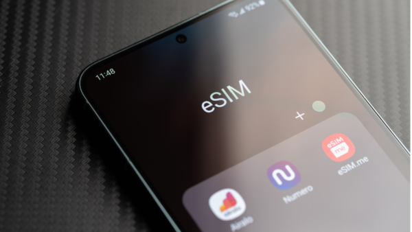 Top half of a smartphone. On the screen is seen a heading sSIM. Below it is a row of 3 icons one of which has the caption eSIM.me. The other two are a bit blurred but are eSIM provider apps.