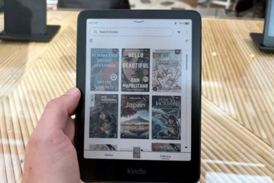 A Kindle ereader showing a home page with colour thumbnails of books.