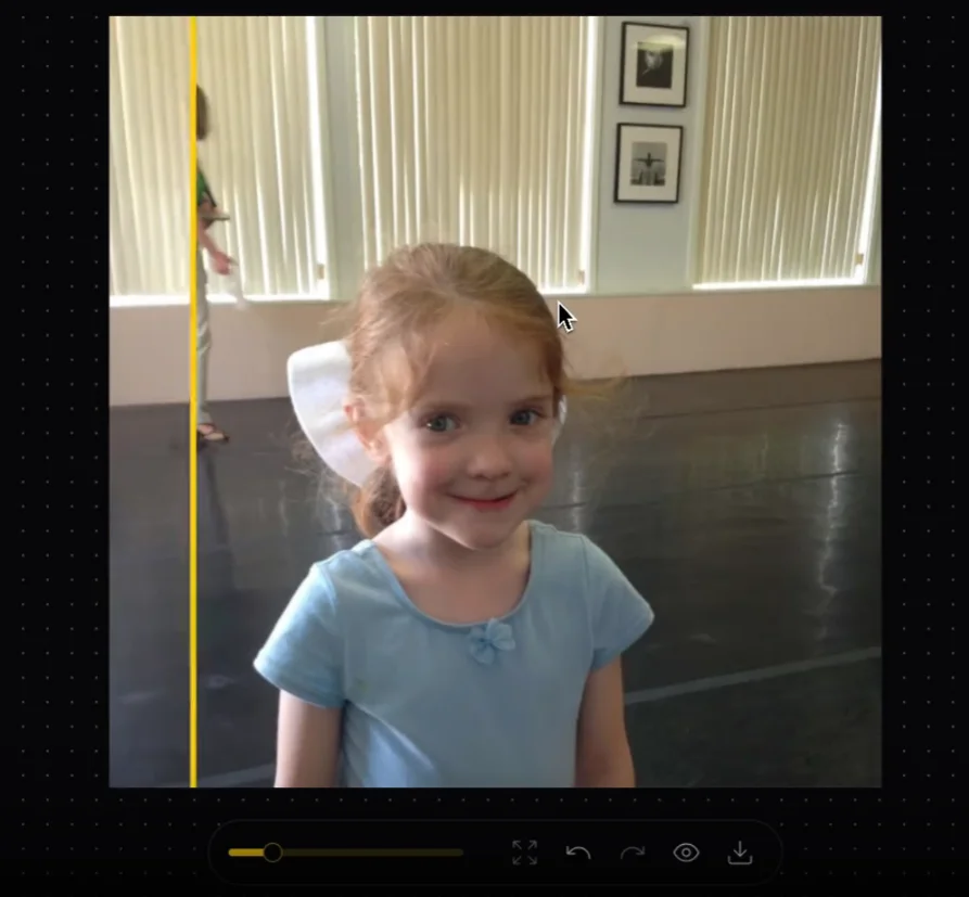 Image of a young girl being edited. A yellow vertical line has dissected a woman standing in the background, so that when slid left or right, it will show a before and after view of the woman in the background having been removed from the photo.