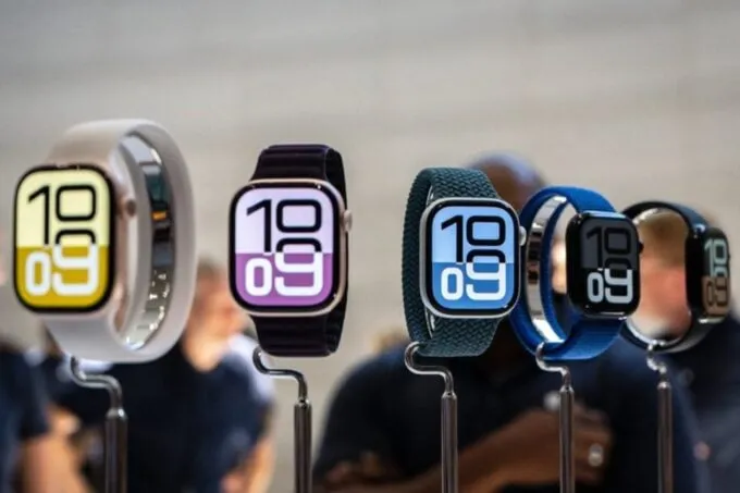 Five Apple Watches all mounted on silver coloured stands next to each other. The faces show large time digits for 10:09.