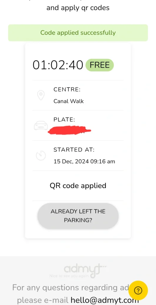 The image shows a mobile phone screen displaying a parking confirmation from admyt. The foreground is dominated by the parking details, including a timer showing 1 hour, 2 minutes, and 40 seconds remaining, along with the location, Canal Walk, and the fact that the parking is free. In the background, there is a simple, clean interface with the admyt logo at the bottom and contact information. The overall color scheme is minimalistic with light greys and greens. The image shows a QR code was successfully applied at 09:16 am, on December 15, 2024. The license plate number is obscured, protecting the user's privacy. The app interface is clearly designed for user-friendliness, making it easy to confirm parking and departure status. The 'Already left the parking?' button indicates a feature that allows the user to easily indicate departure.