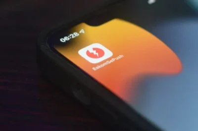 Close-up of a smartphone screen displaying the EskomSePush app icon with a lightning bolt, set against an orange background.