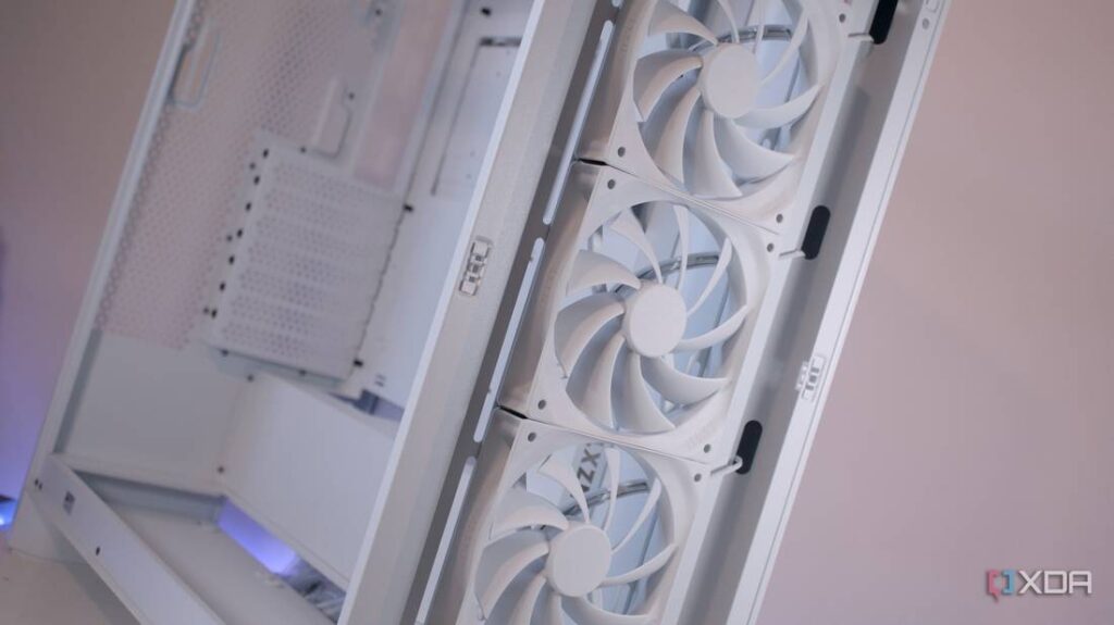 A close-up view of a white PC case featuring three large front-mounted cooling fans and a perforated side panel.