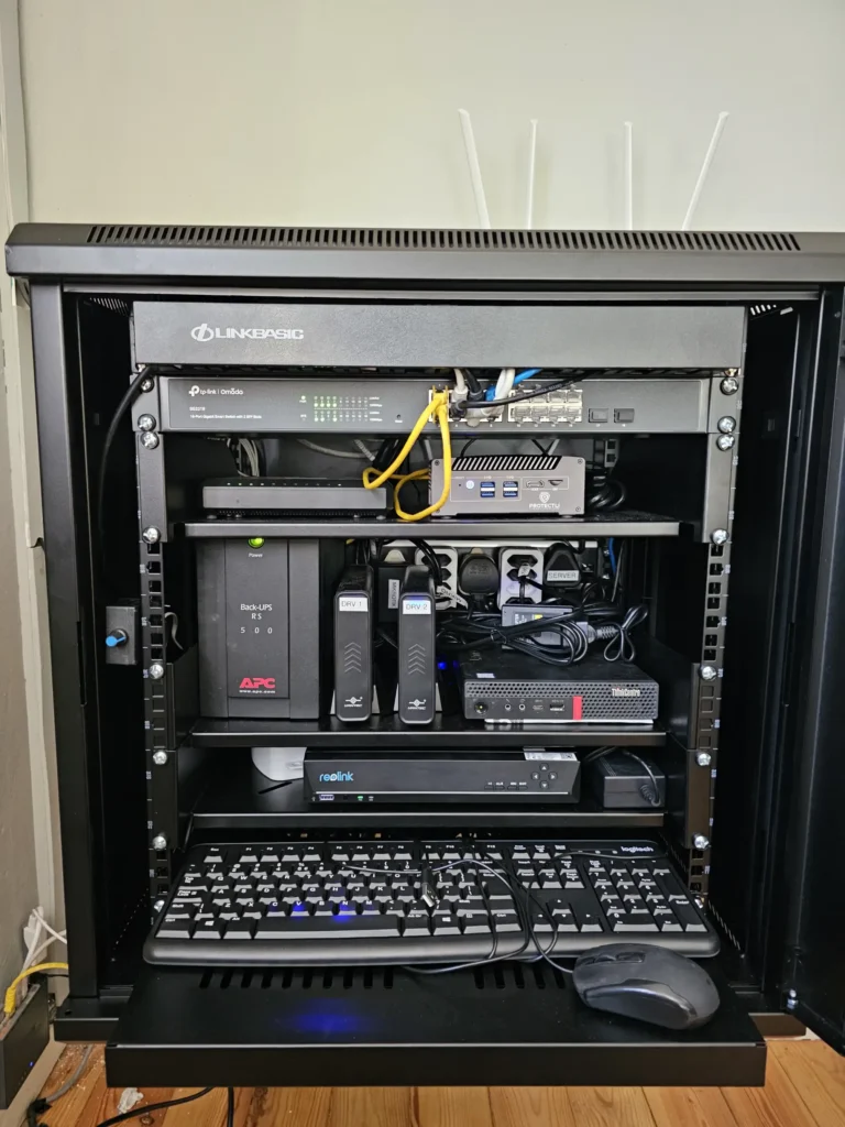 A neatly organized electronic rack showcasing network equipment, a UPS, and a keyboard with a mouse on the bottom shelf.