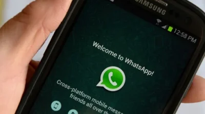 Unlike Signal, WhatsApp provides no cryptographic management for group messages 9 A hand holding a smartphone displaying the WhatsApp welcome screen, featuring the logo and a brief description of the app's features.