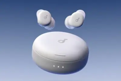 Anker’s Soundcore Sleep earbuds finally feature active noise cancelling - At a Price 2 White wireless earbuds floating above their charging case with three LED indicator lights, against a gradient blue background.