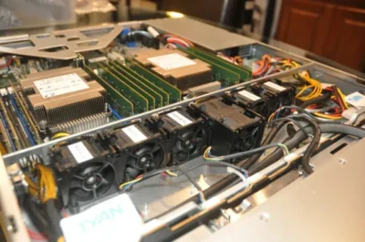 Close-up of a computer server interior, featuring RAM modules, heatsinks, and cooling fans, showcasing intricate wiring and components.