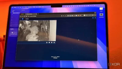 A laptop screen displays a web interface for a security camera, showing a nighttime view of a balcony and surrounding area.
