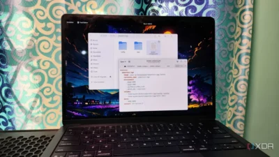 A laptop screen displaying a code editor with a Docker Compose file and file manager, set against a colorful backdrop.