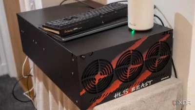 A black computer chassis with a striking "HL15.BEAST" label, three cooling fans, a Ducky keyboard, and a Deco router on top.