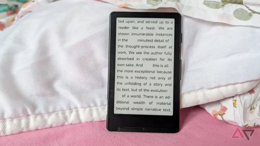 An e-reader displays text discussing the intricacies of storytelling and narrative evolution, resting on a patterned blanket.