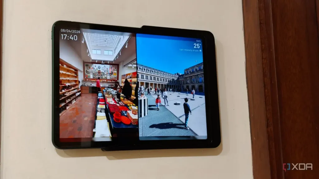 Tablet mounted on a wall displaying a split screen with a store interior on the left and an outdoor plaza with people on the right.