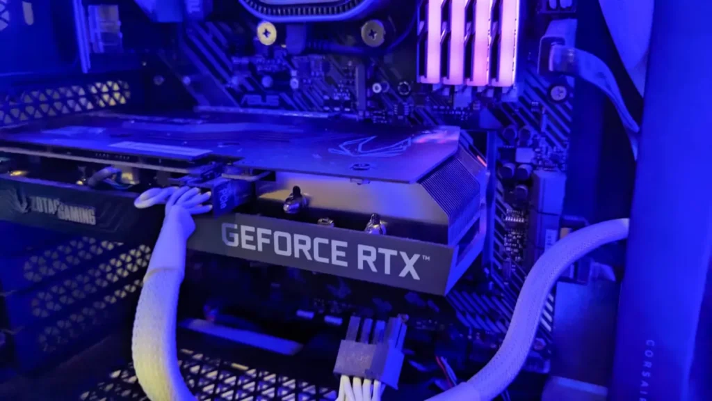 Close-up of a gaming PC interior featuring a Zotac Gaming graphics card and a GeForce RTX GPU with blue LED lighting.