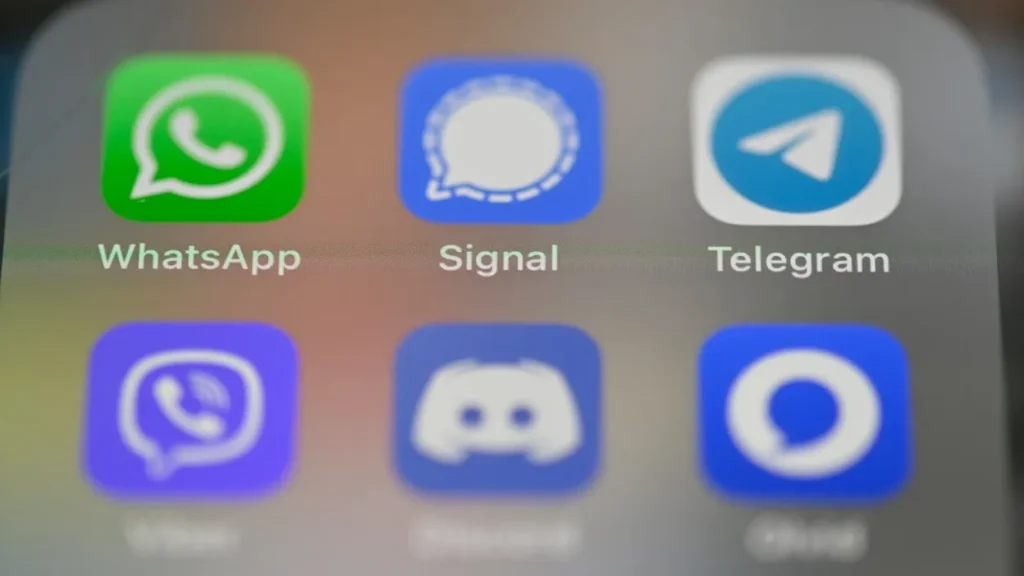 Close-up of smartphone screen showing messaging app icons: WhatsApp, Signal, Telegram, Viber, Discord, and Otter.ai.