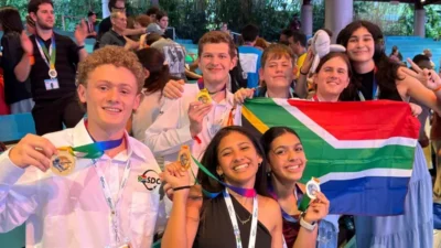 Team South Africa wins at NASA space engineering competition 2 Group of smiling young people proudly holding medals and a South African flag at an award event.