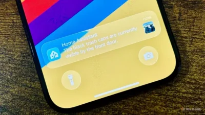 Smartphone screen showing a Home Assistant notification about black trash cans visible by the front door.
