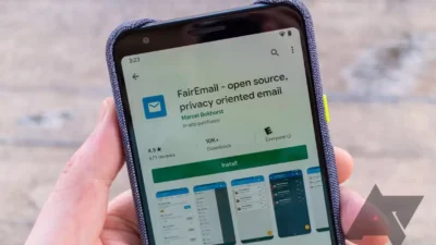 Hand holding a phone displaying the FairEmail app page on the Google Play Store with an install button visible.